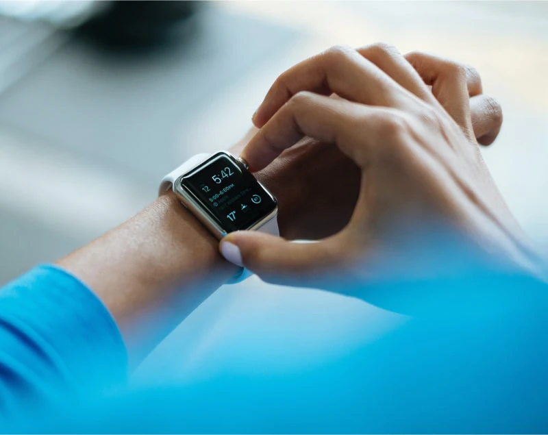 An arm with a hand adjusting an Apple Watch