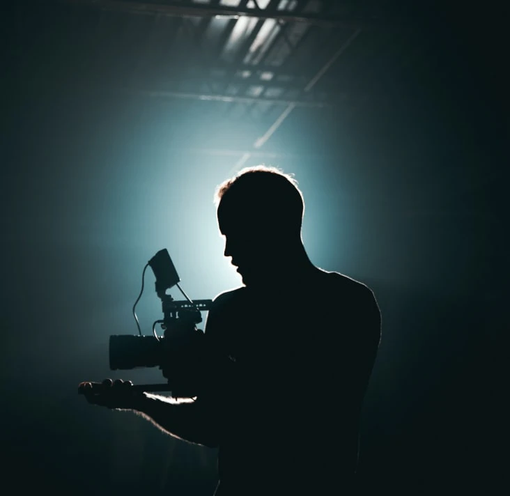 Silhouette of a person operating a camera